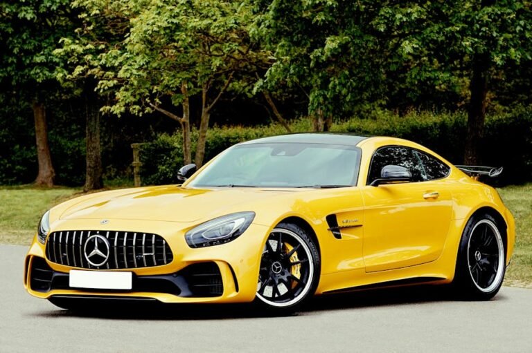 An elegant yellow sports car parked outdoors in a park setting, surrounded by lush greenery.