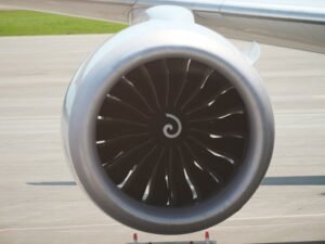 Detailed view of a modern airplane jet engine on an airport tarmac.