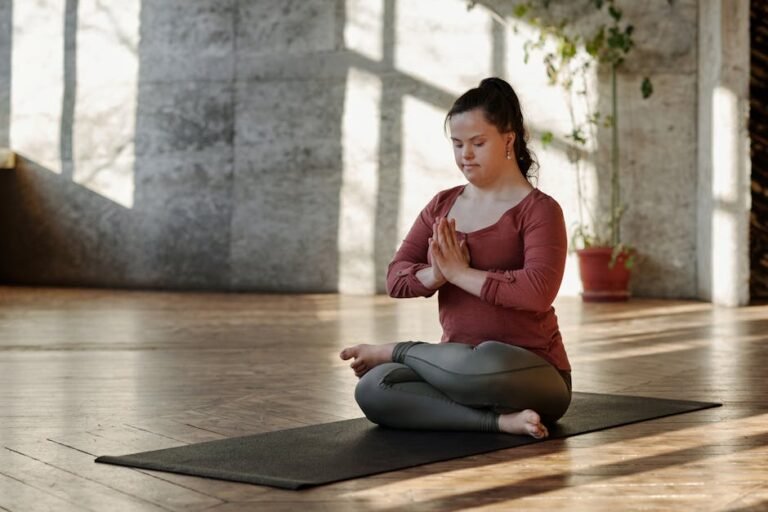 Woman practicing yoga on a mat indoors, finding inner peace and relaxation in a serene setting.