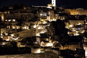 Captivating night view of Matera's ancient illuminated architecture showcasing unique Italian heritage.
