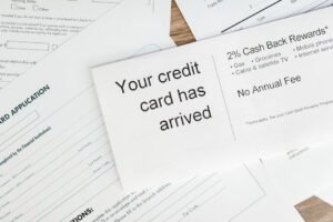 Close-up of a letter announcing the arrival of a credit card amidst financial documents.